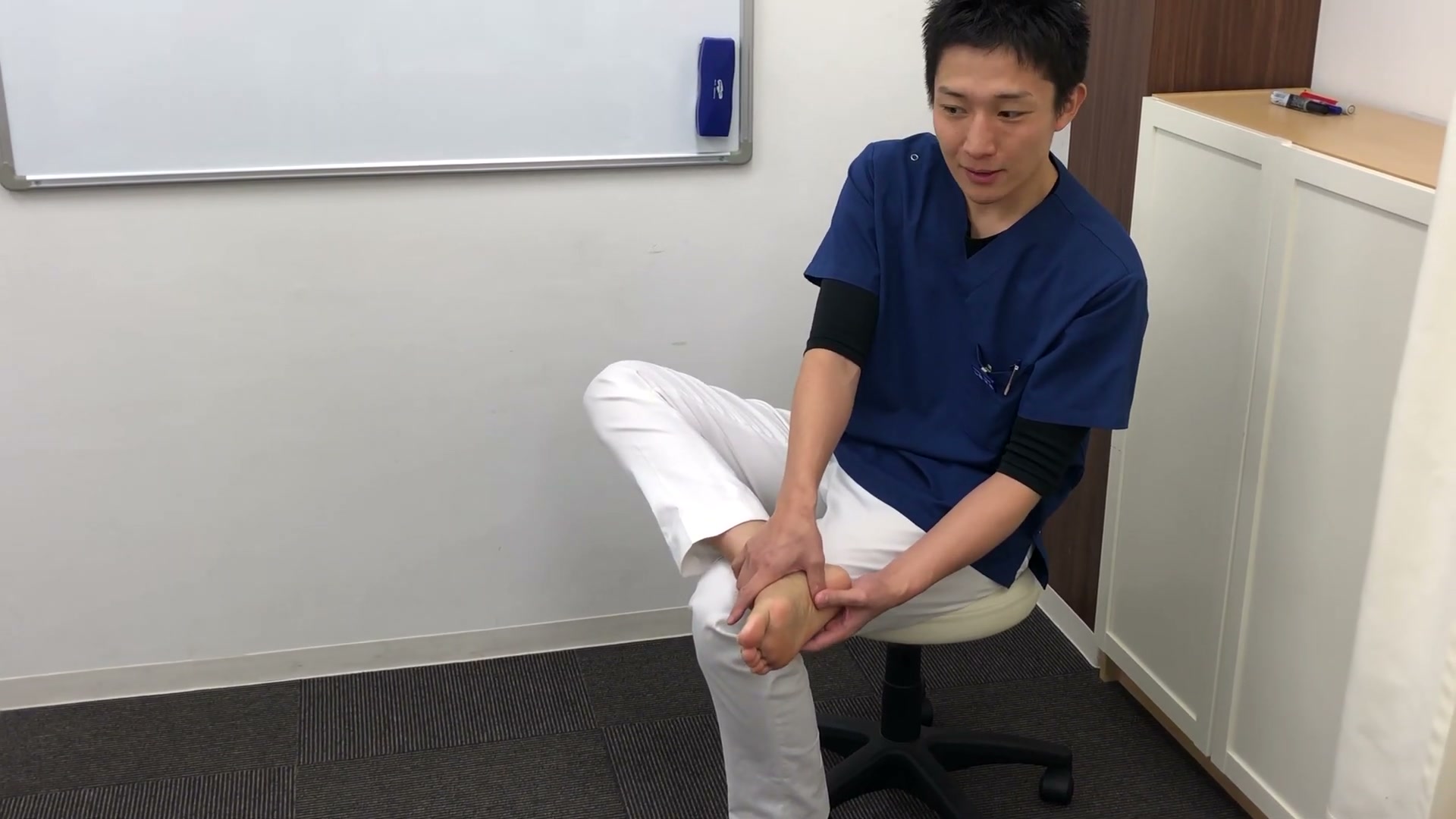 足裏のかかと内側の痛い場所を指で押して探す様子
