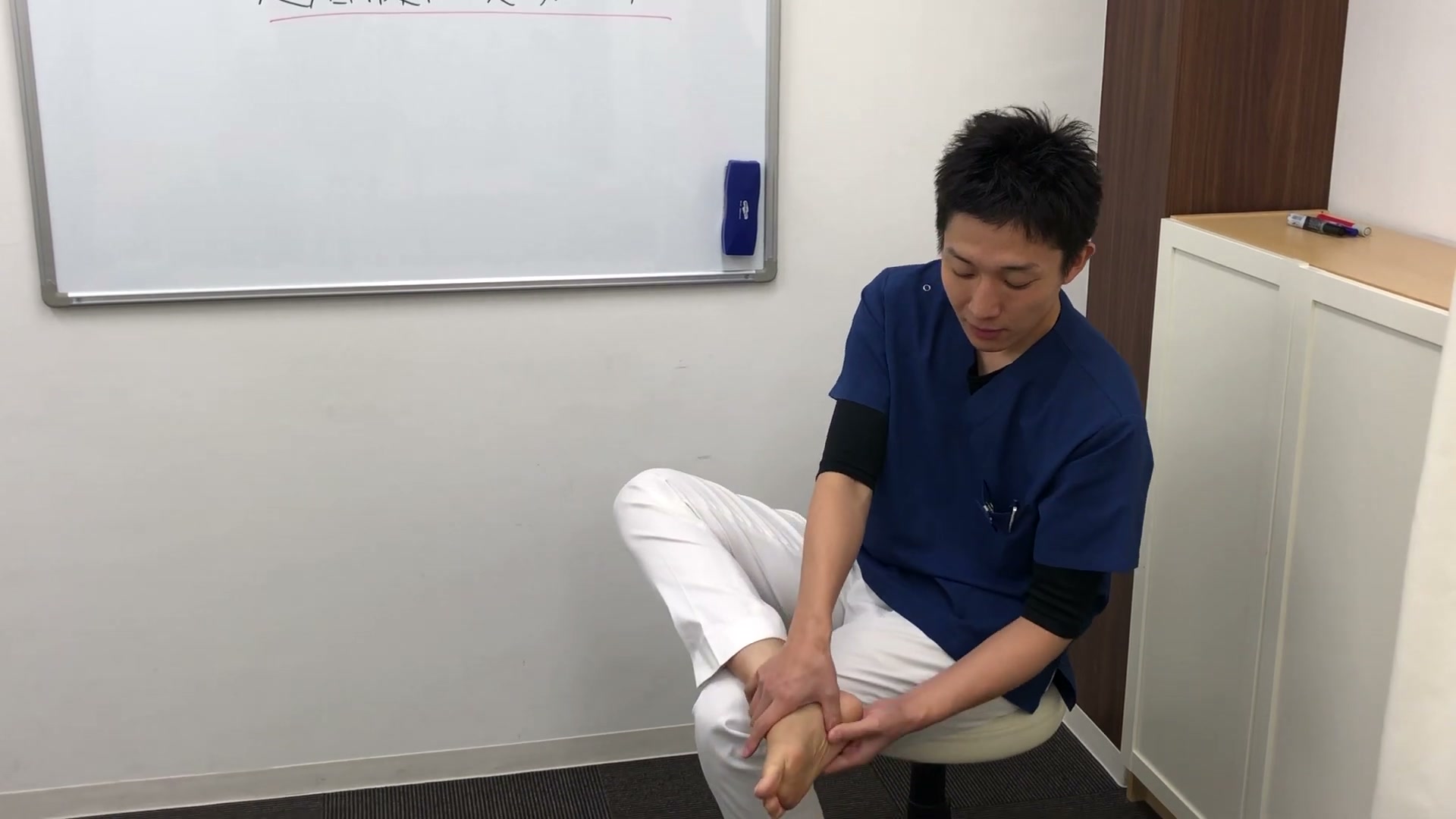 足底腱膜炎の痛点を指で押さえて確認する様子